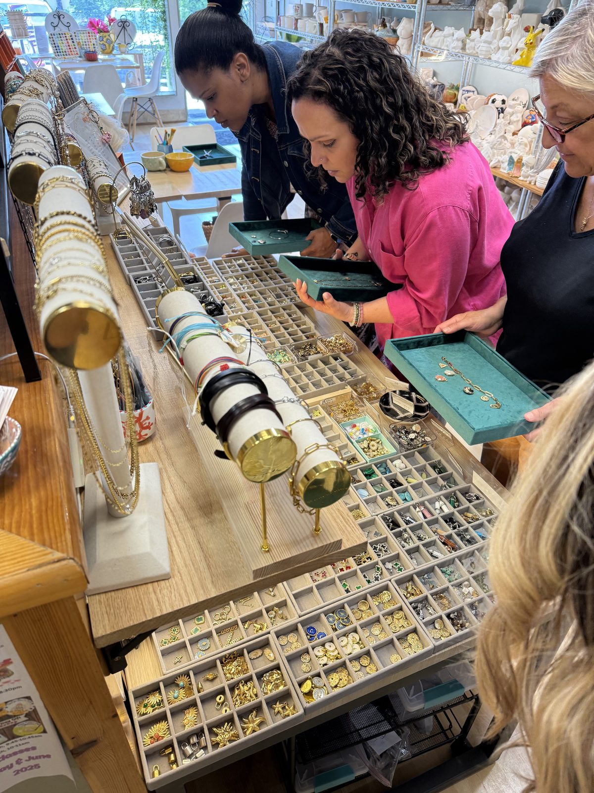 Customers choosing charms at the Charm Bar station inside the studio