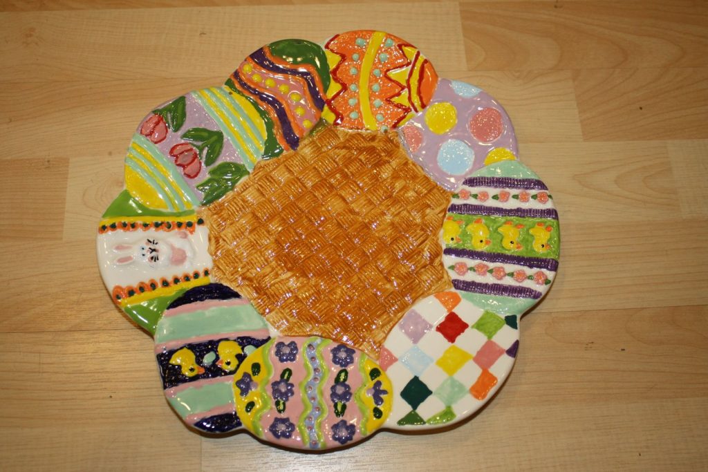Scalloped hand-painted Easter egg platter with each section decorated in different colorful egg patterns
