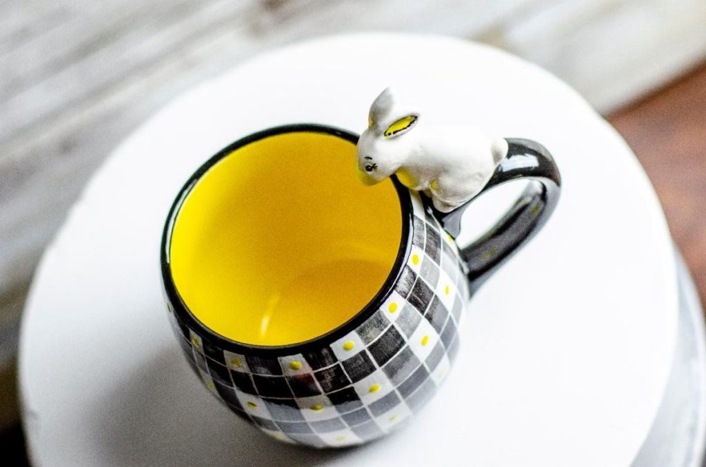 Black and white checked hand-painted mug with yellow interior and a small bunny on the rim