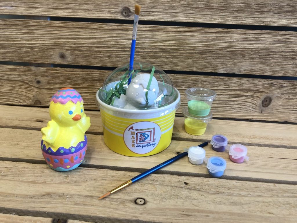 Paint-at-home kit cup with a hand-painted yellow chick hatching from an Easter egg and paint pots