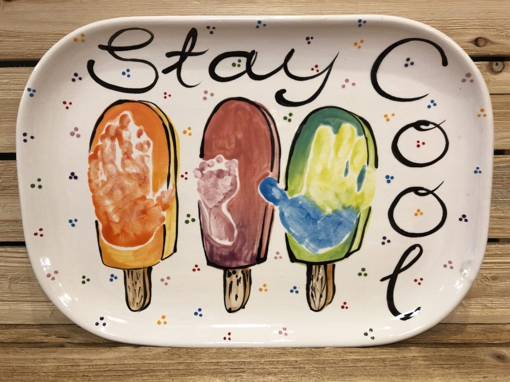 Stay Cool serving platter with handprint and footprint popsicles in orange, brown and green