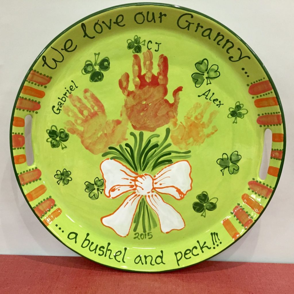 Lime green round tray with orange handprints as a flower bouquet for Granny