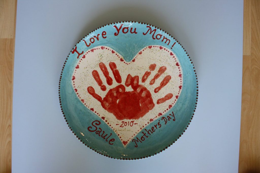 Hand-painted I Love You Mom plate with red handprints inside a heart on an aqua rim