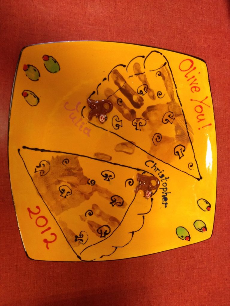 Hand-painted yellow square platter with handprint pizza slices and Olive You lettering, dated 2012