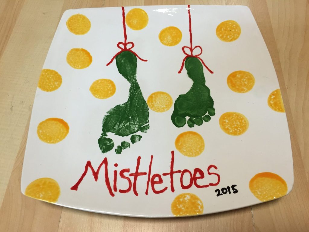 Hand-painted square Mistletoes platter with green footprints on yellow polka dots, dated 2015