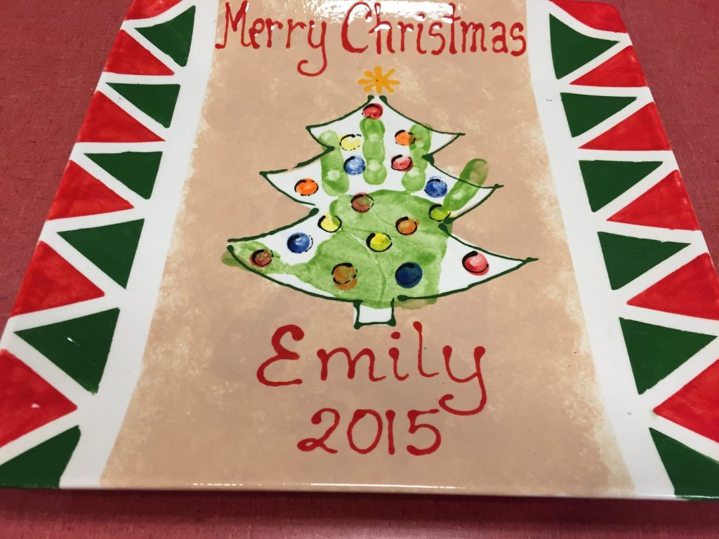 Hand-painted Merry Christmas platter with a fingerprint tree and red and green triangle border, dated 2015