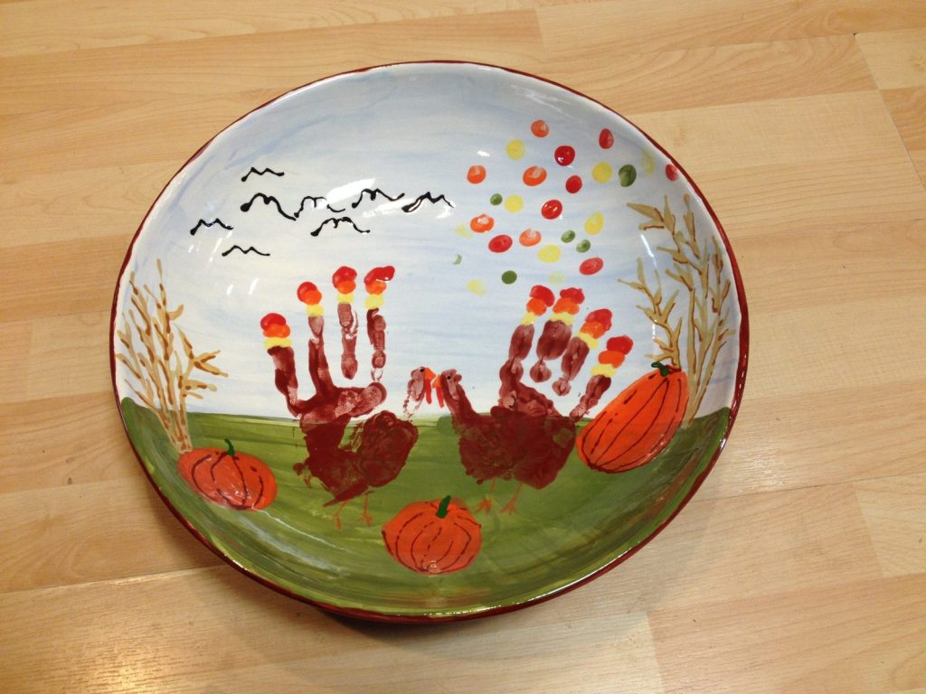 Hand-painted bowl with brown handprint trees, pumpkins and falling autumn leaves