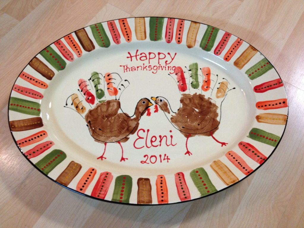 Hand-painted oval Happy Thanksgiving platter with two handprint turkeys and a striped rim, dated 2014