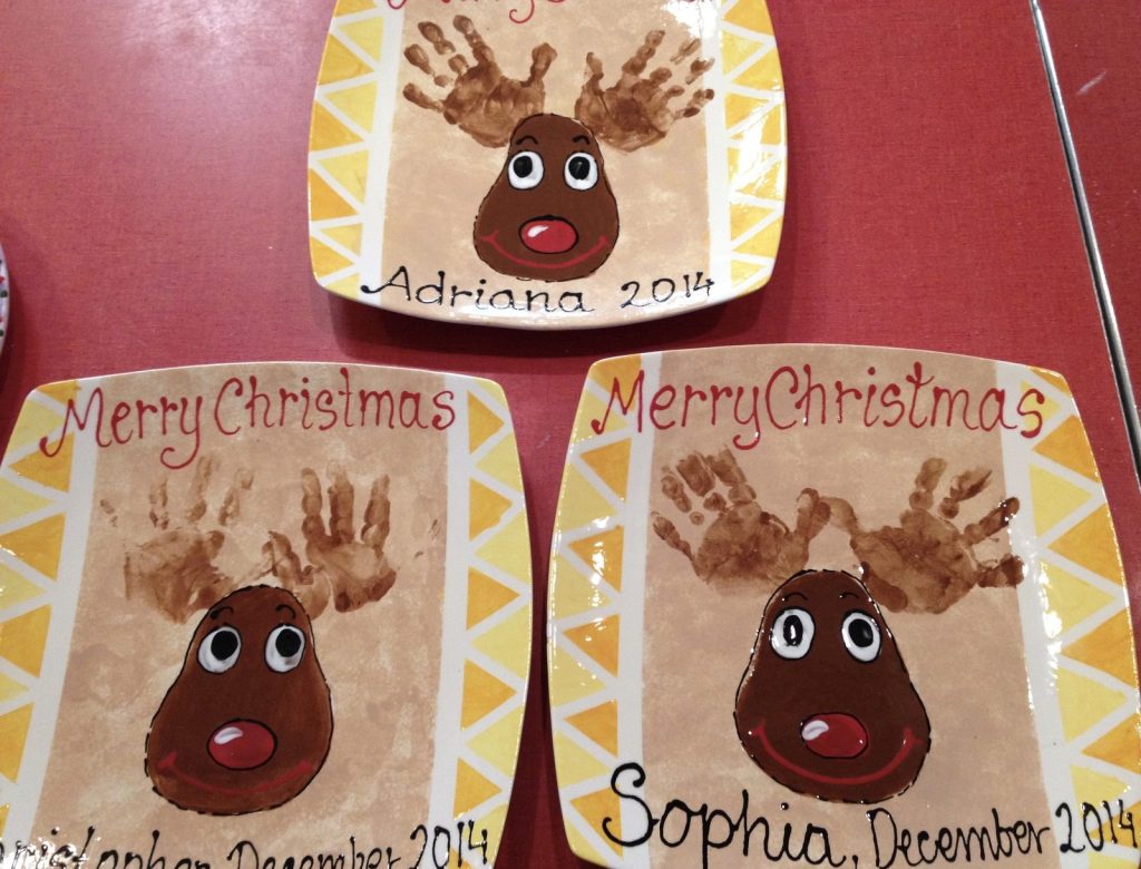 Three hand-painted Merry Christmas plates with handprint antler reindeer and yellow triangle borders