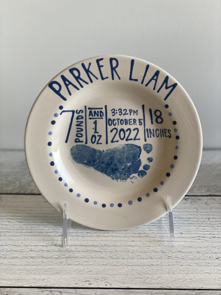 Hand-painted birth announcement plate with a blue baby footprint and birth stats, dated 2022