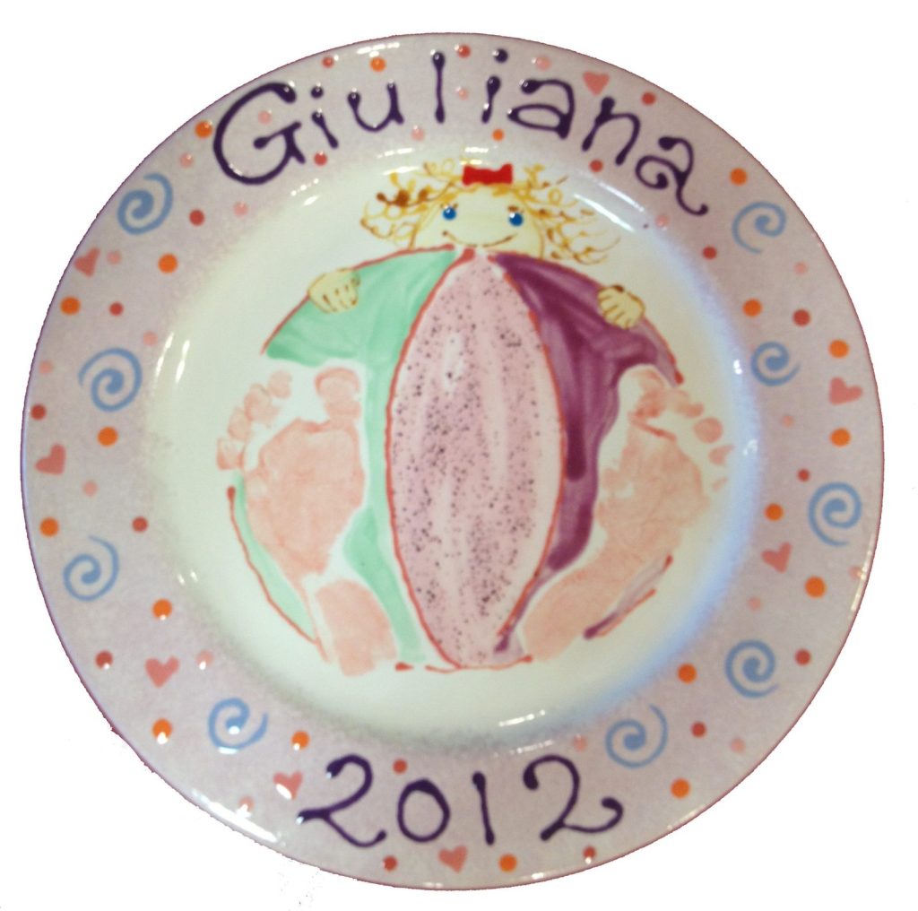 Hand-painted plate with pink footprints forming a princess ball gown on a pastel swirl border, dated 2012