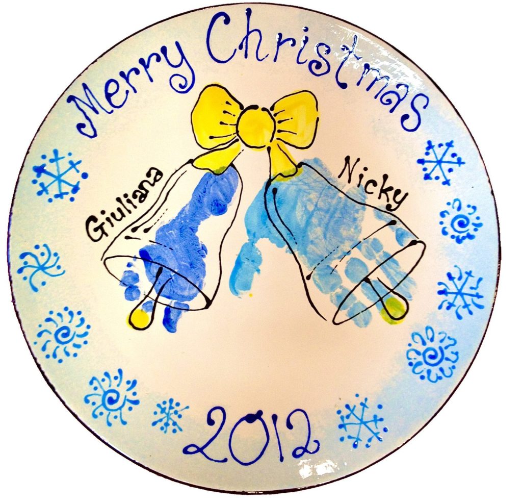 Hand-painted Merry Christmas plate with blue footprint bells, a yellow bow and snowflakes, dated 2012