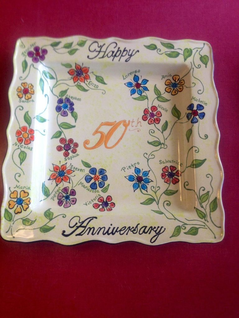 Scalloped square 50th anniversary plate with colorful flowers, each labeled with a family member's name