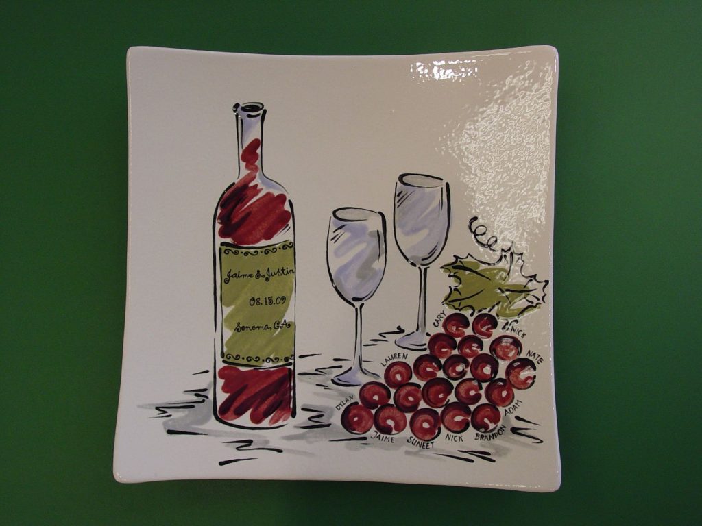 Square platter with a wine bottle, glasses and grapes labeled with family names, wedding anniversary gift
