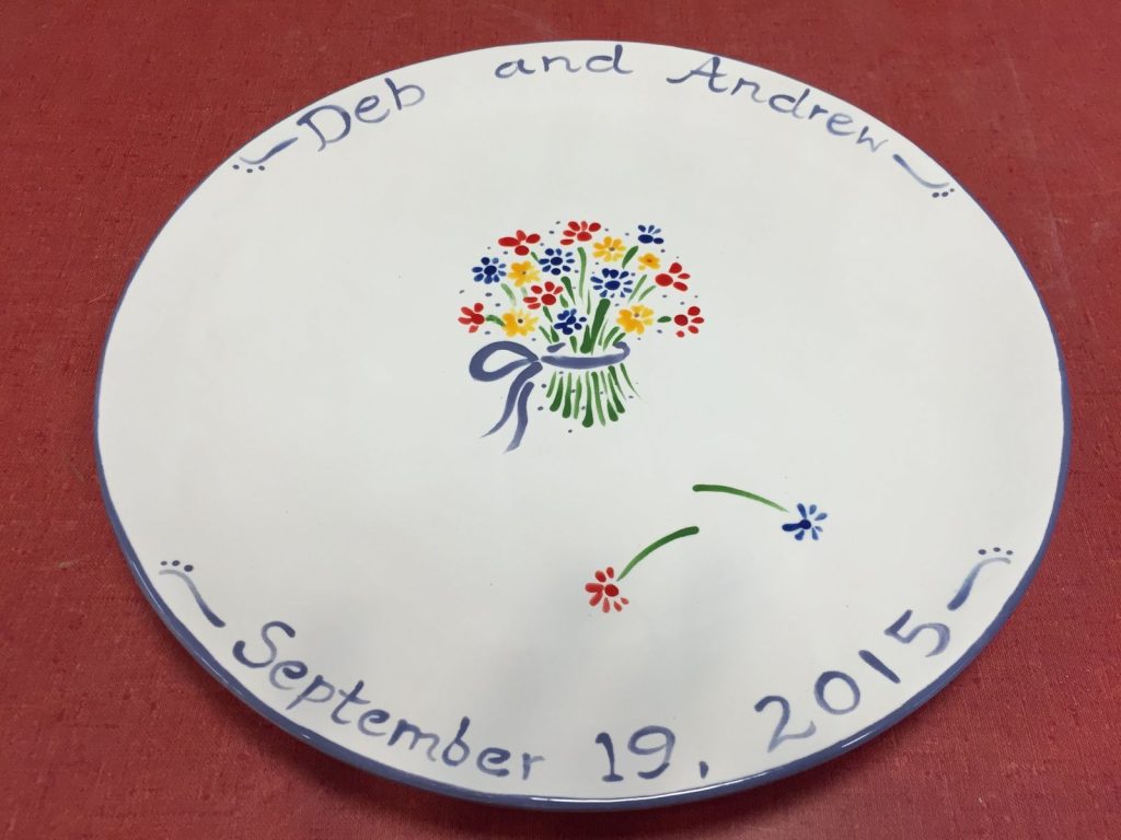 Round anniversary plate with a bright flower bouquet, a script border and the wedding date
