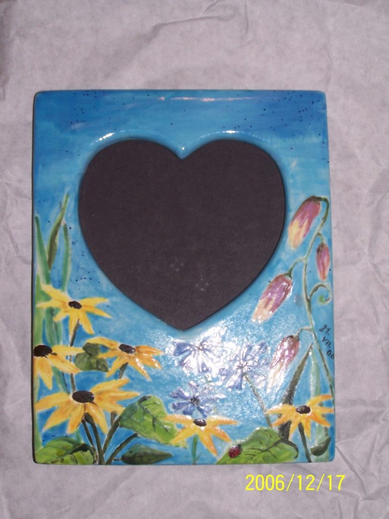 Hand-painted blue picture frame with a heart-shaped opening and black-eyed Susans