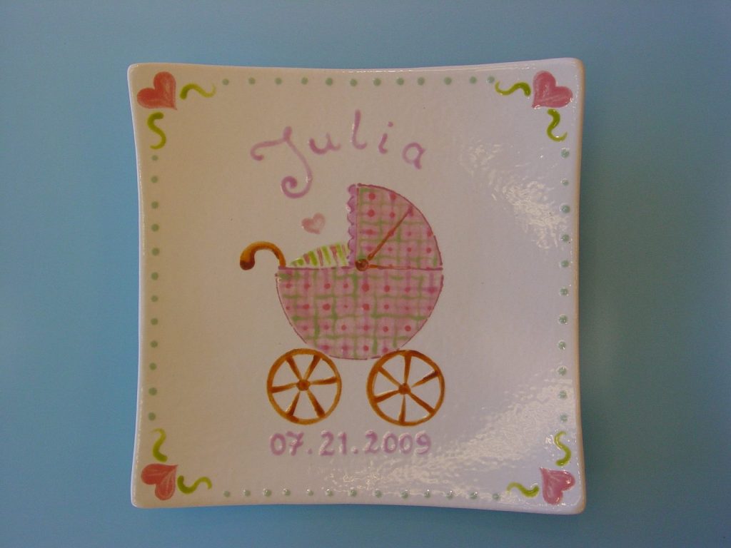 Hand-painted square baby plate with a pink plaid carriage and hearts, dated 2009