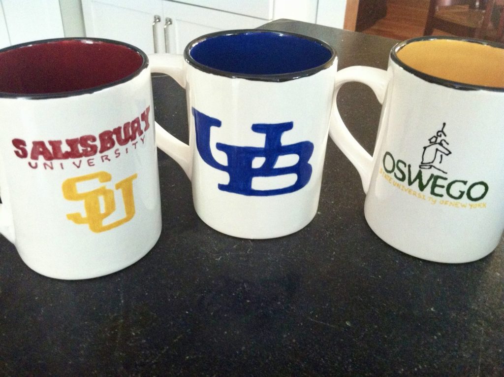 Three hand-painted college mugs with Salisbury, UB and Oswego logos in school colors