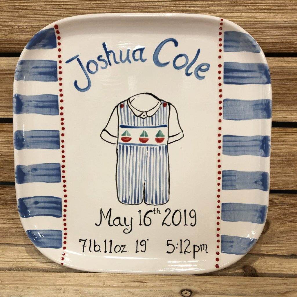 Hand-painted birth announcement platter with a blue striped border and sailboat romper, dated 2019