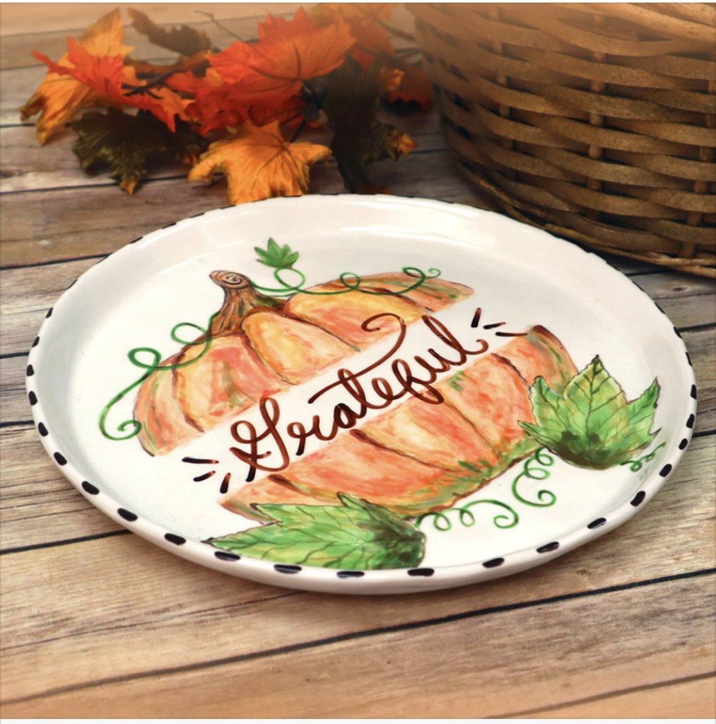 Hand-painted white plate with a watercolor pumpkin wrapped in a Grateful banner and black dotted rim