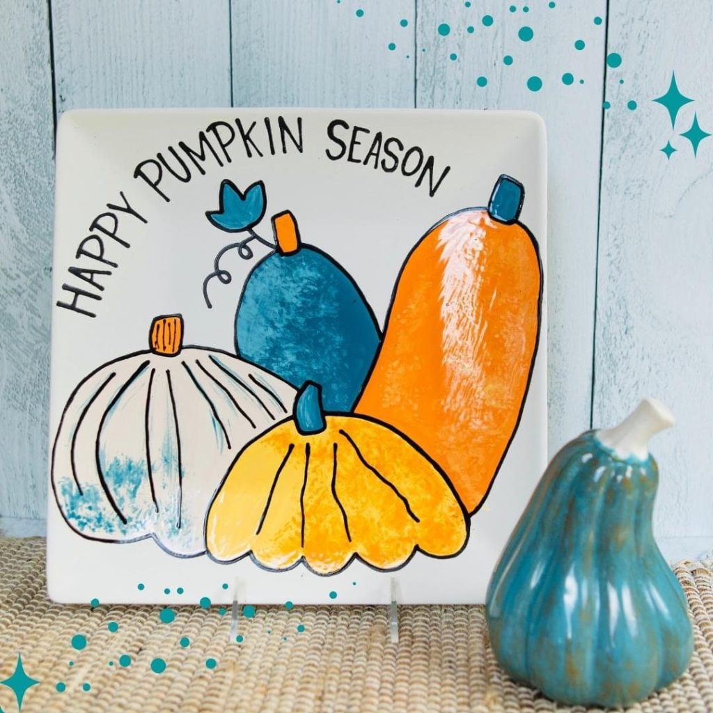Hand-painted square plate reading Happy Pumpkin Season with teal, yellow, and orange pumpkins