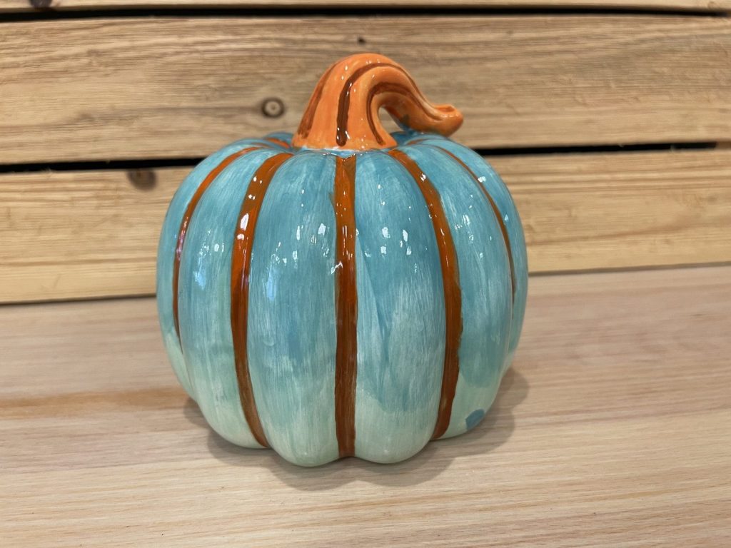 Hand-painted turquoise pumpkin with brown stripes and an orange curled stem