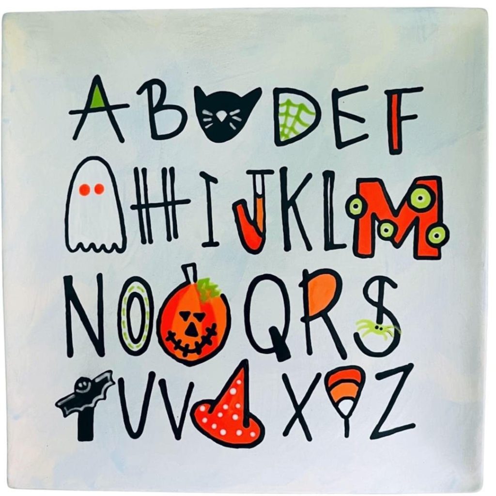 Hand-painted square alphabet plate with Halloween letters including a cat, ghost, pumpkin, and witch hat