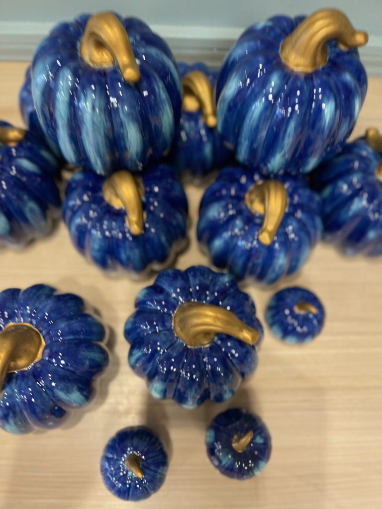 Collection of hand-painted cobalt blue pumpkins in different sizes with gold stems