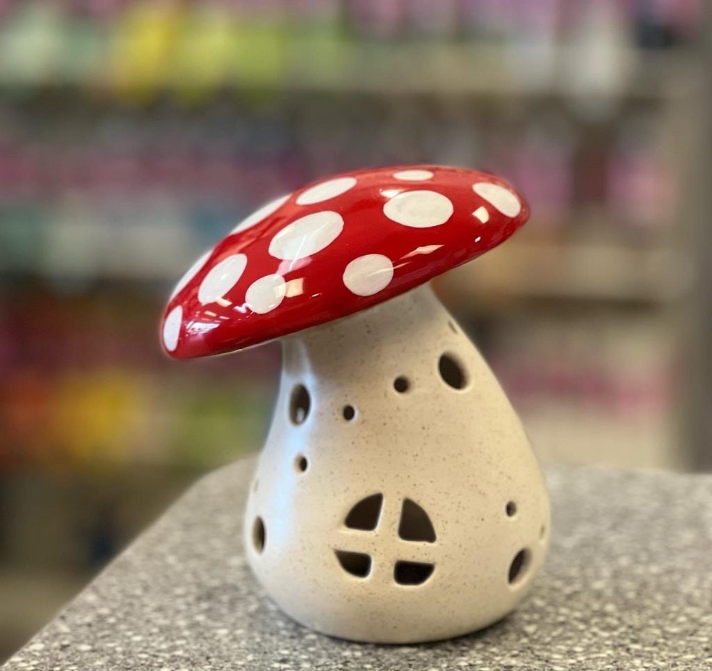 Hand-painted mushroom house lantern with a red spotted cap and window cutouts