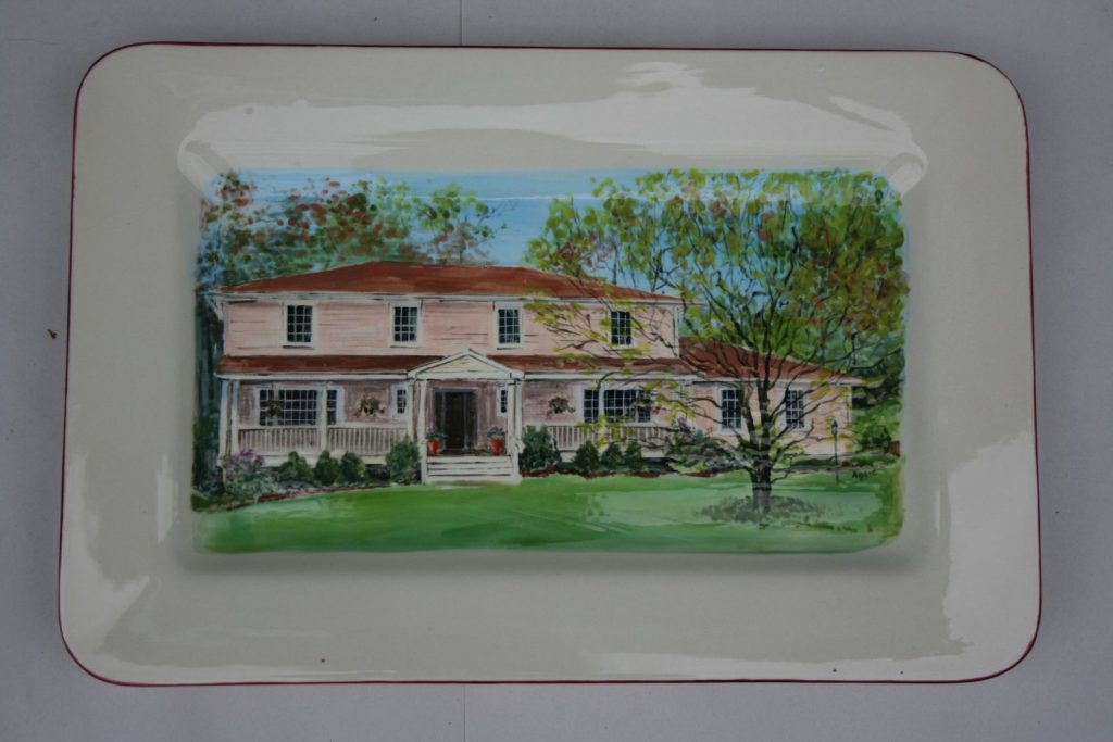 Hand-painted rectangular platter of a pink two-story house with a columned porch and spring foliage