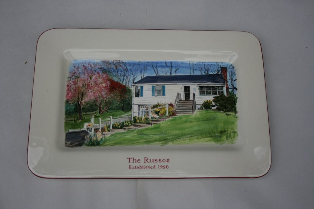 Hand-painted rectangular platter of a white ranch house with spring blossoms and yellow daffodils