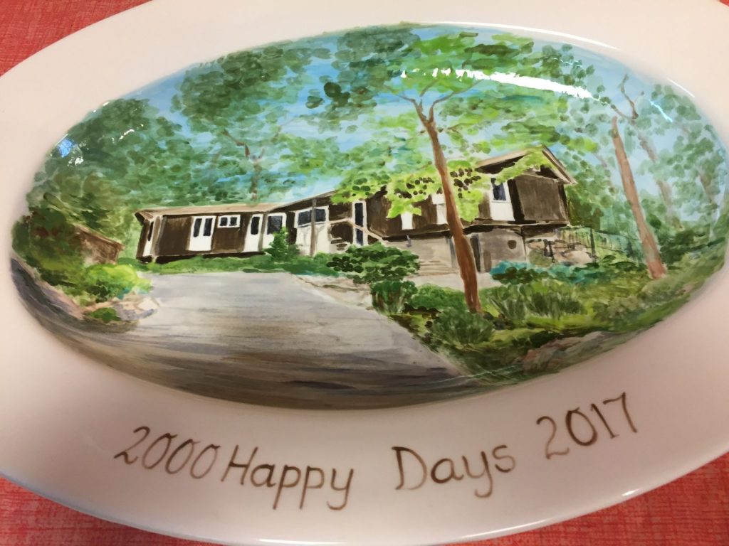 Hand-painted oval platter of a wooded modern home with a winding driveway, inscribed Happy Days 2017