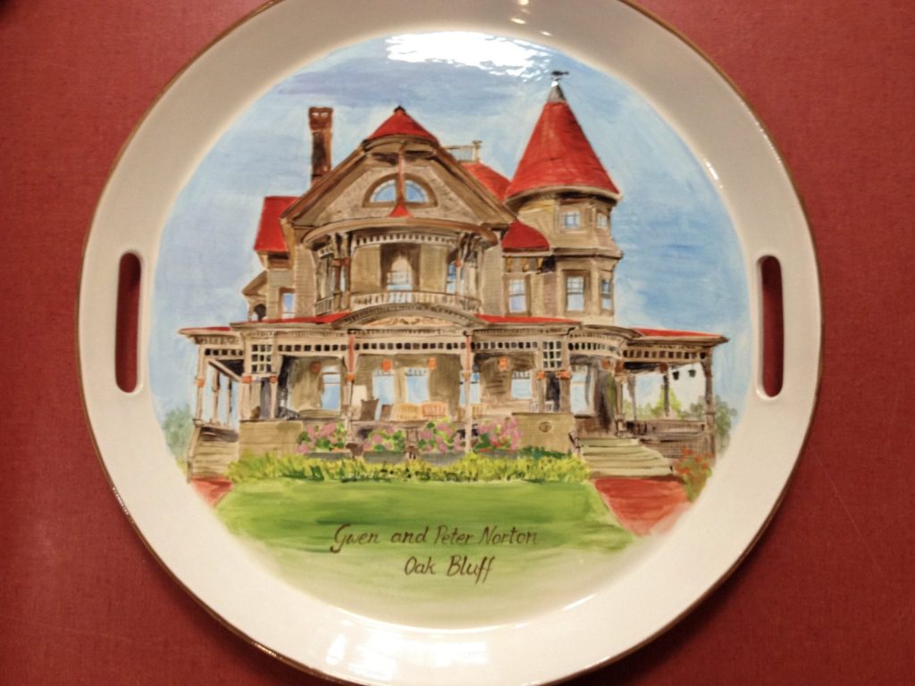 Hand-painted round handled platter of a Victorian mansion with a red turret and wraparound porch