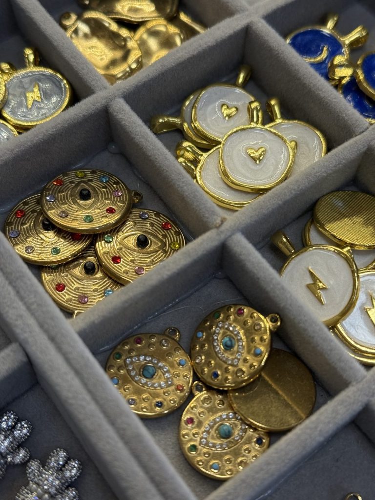 Gold evil eye medallions and white enamel charms
