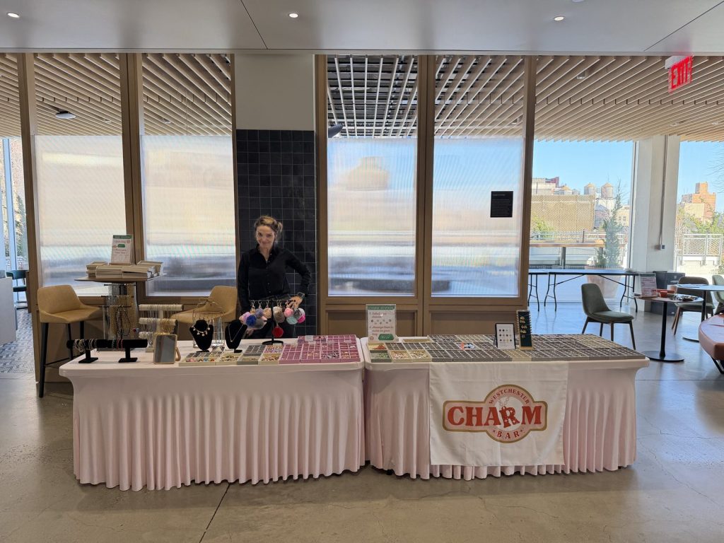 A Mobile Charm Bar table at a corporate event, in front of floor-to-ceiling windows