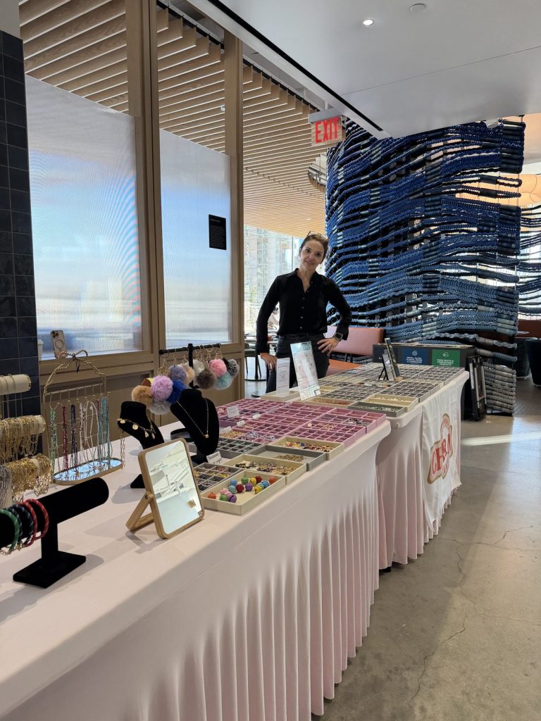 A Charm Bar host at a long Mobile Charm Bar table at a corporate event