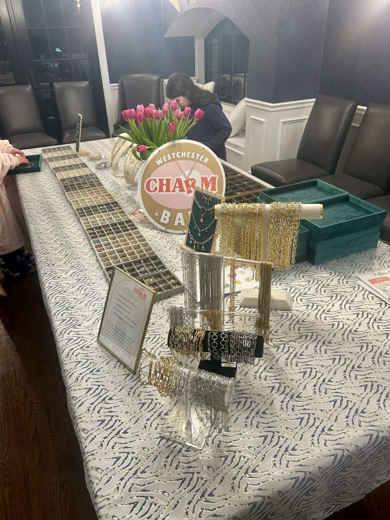Charm Bar table with tulips, bracelet displays and the Westchester Charm Bar sign