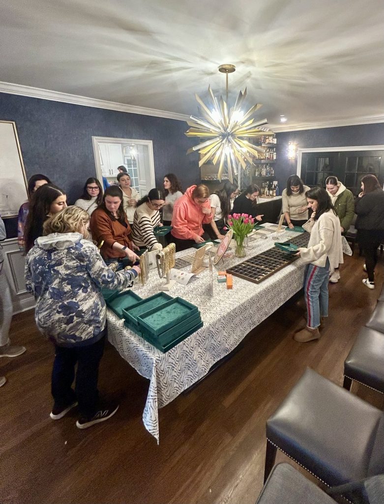Guests choosing charms around a long table at a private party