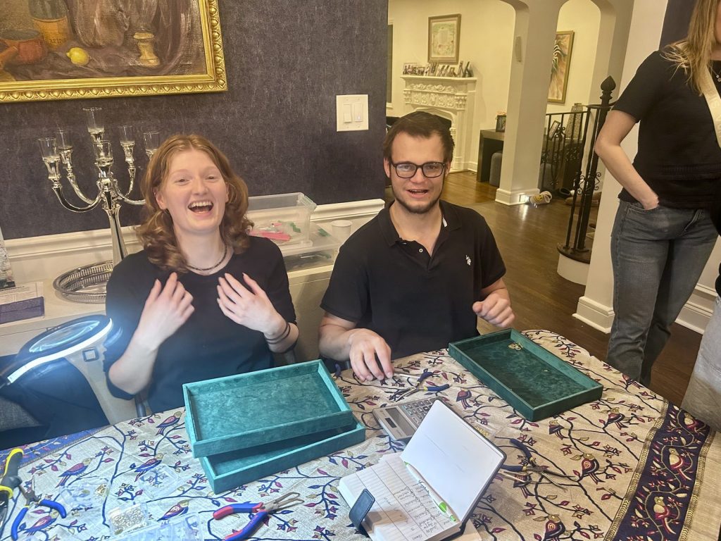 Two guests laughing as they design their jewelry at a Charm Bar party