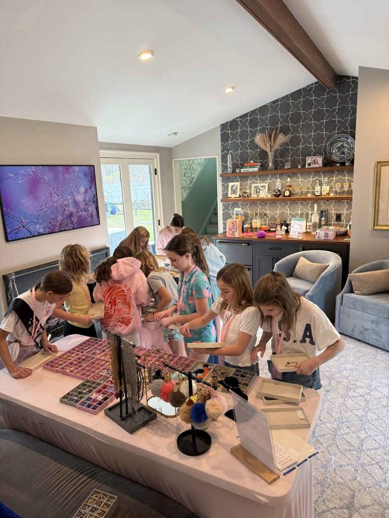 Kids designing jewelry at a Charm Bar party in a living room