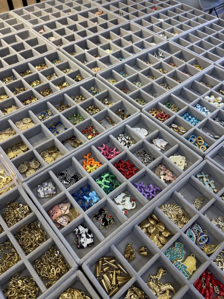 Rows of charm trays laid out for a Charm Bar event
