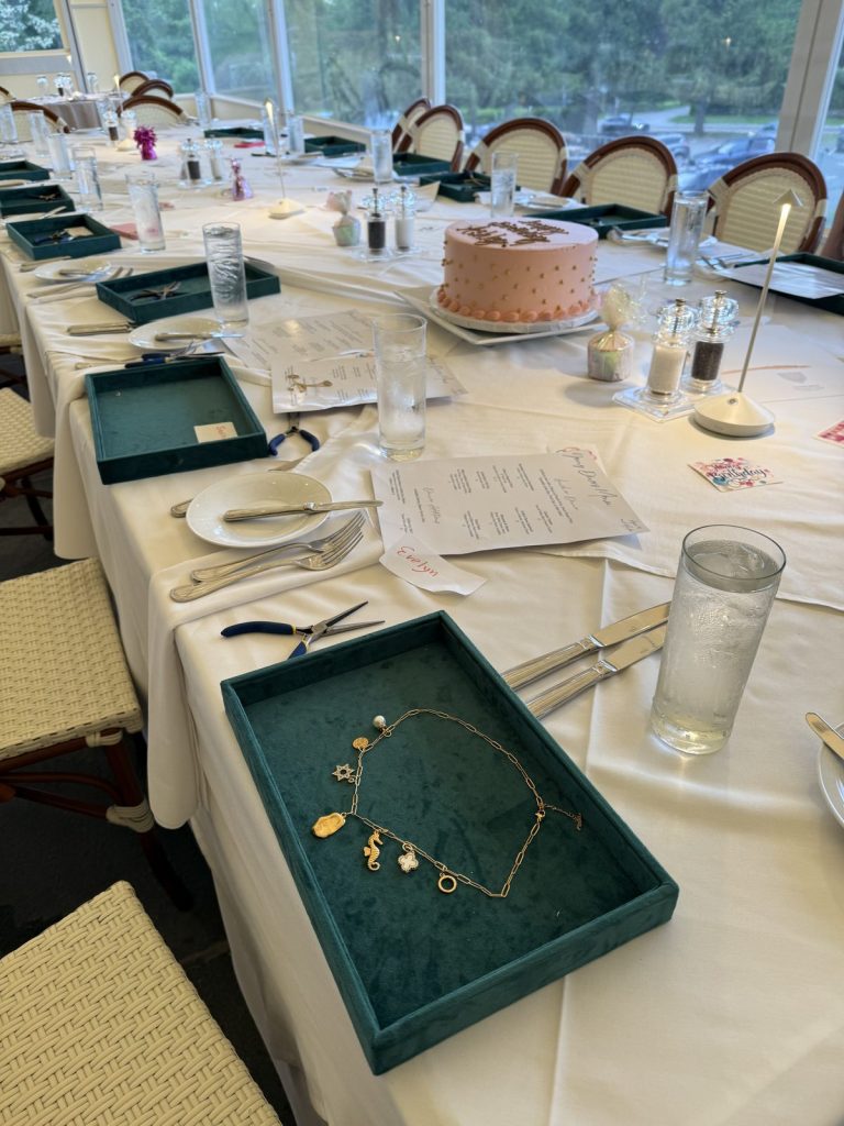 Green charm trays set at each seat for a jewelry-making luncheon