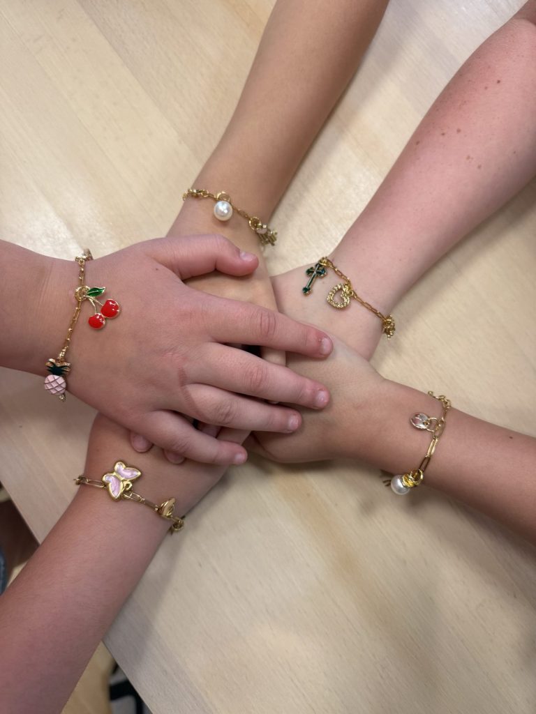 Kids showing off their new charm bracelets