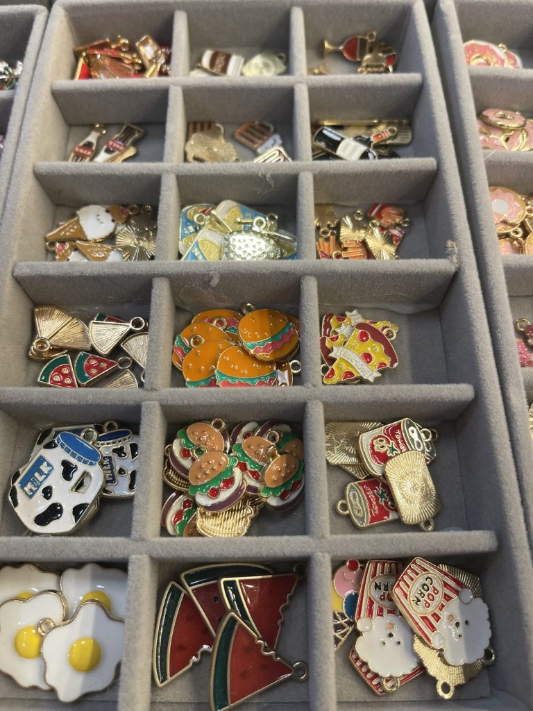 Enamel charms including pizza, fried eggs, cows and watermelon