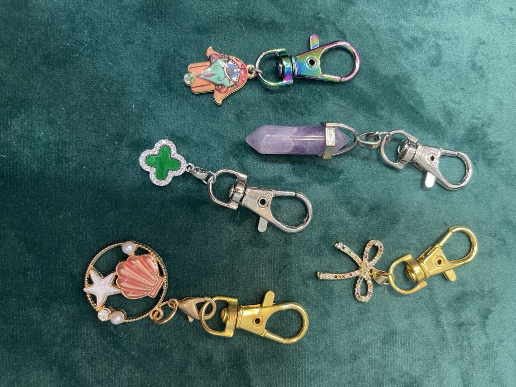 Charm keychains with a clover, a crystal point and a seashell