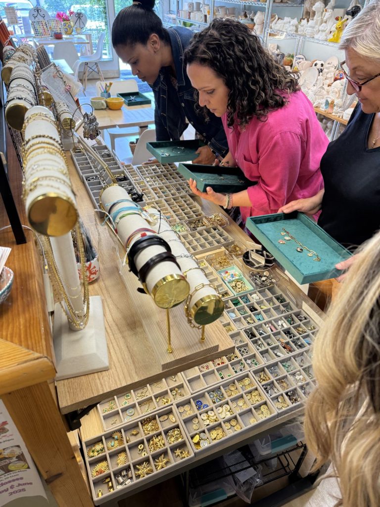 Women choosing charms at the bracelet bar