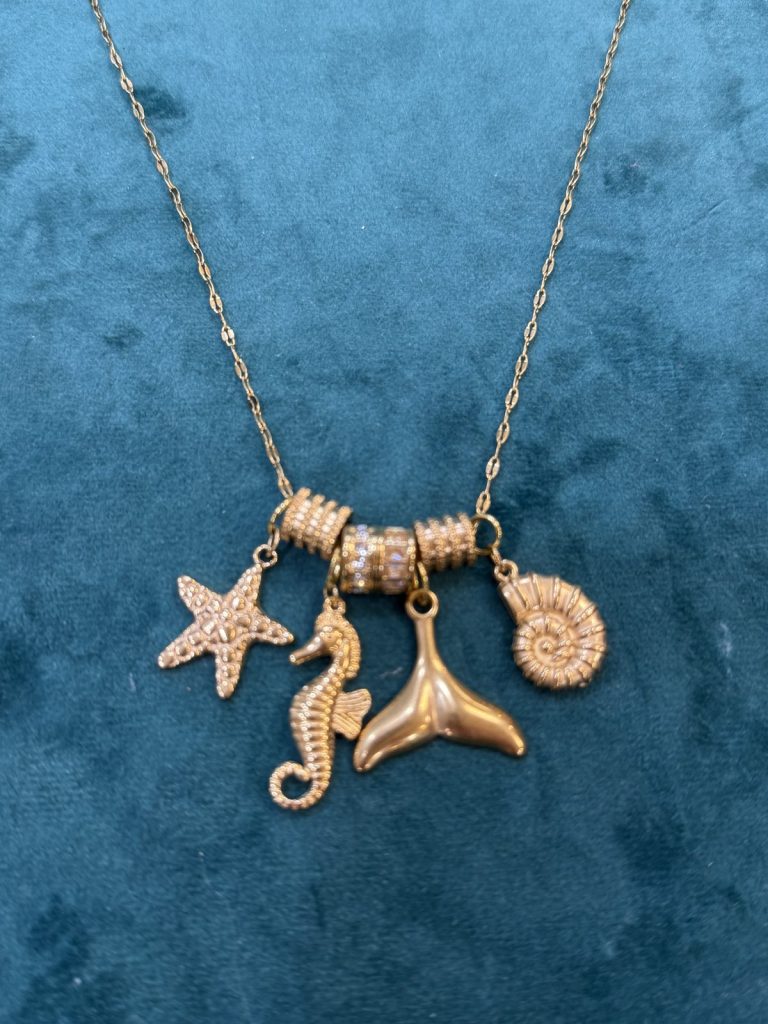 Gold necklace with starfish, seahorse, whale tail and seashell charms