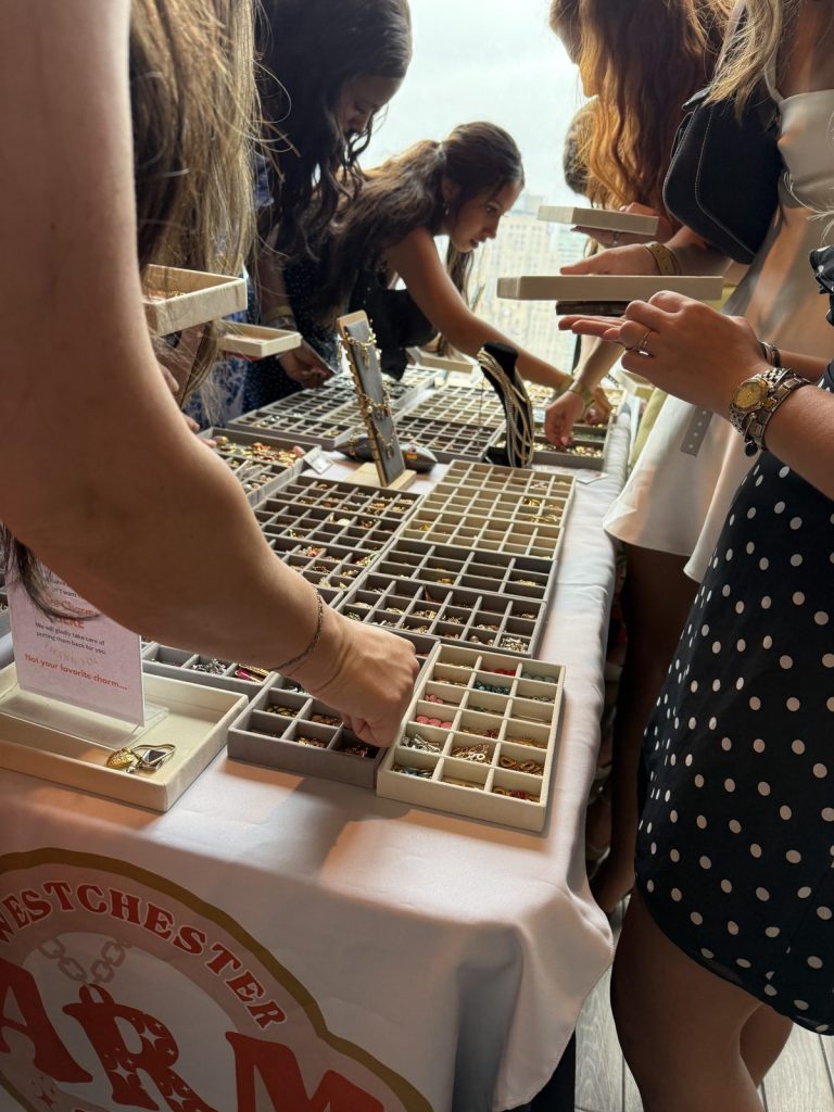 Hands picking charms from the trays at a Mobile Charm Bar event