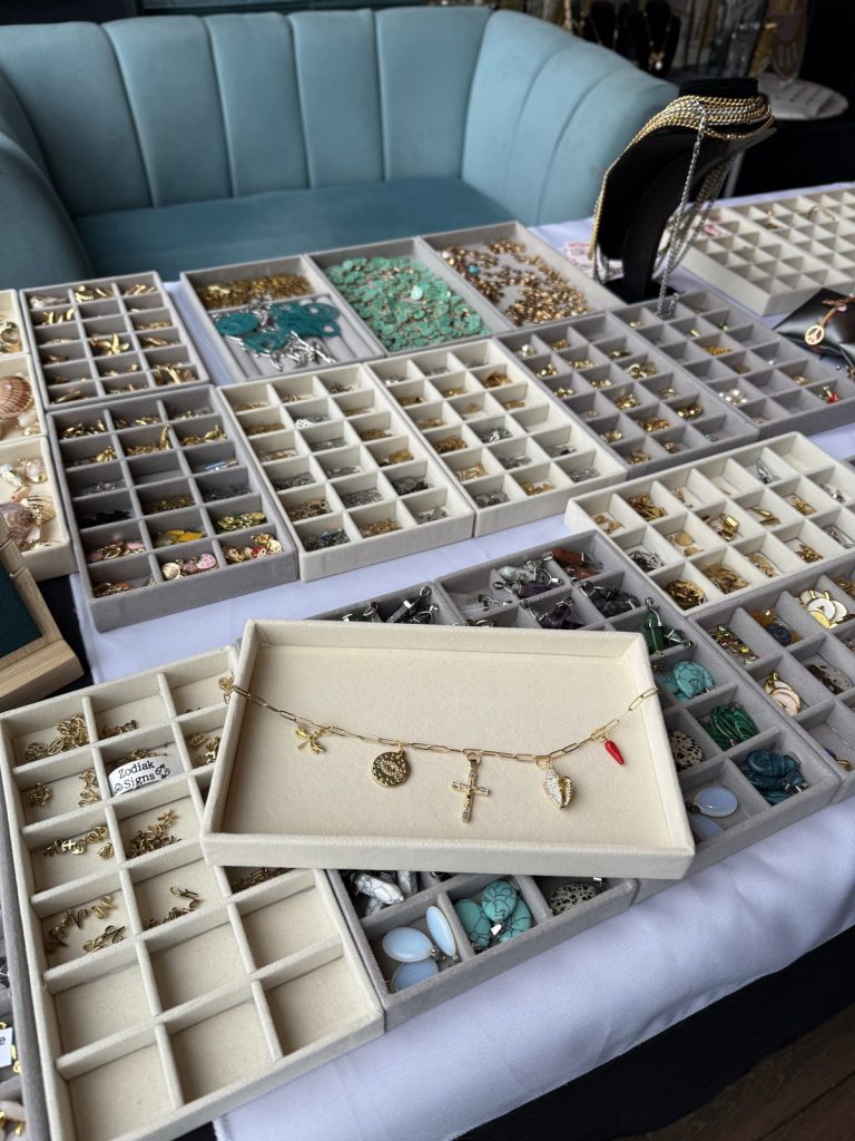 A finished bracelet on a tray beside the charm selection