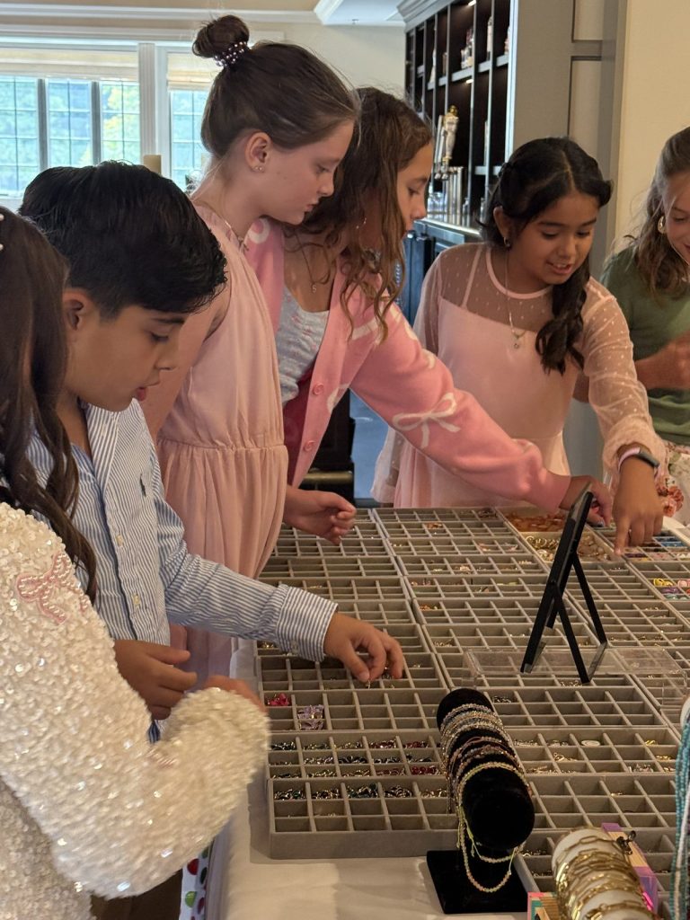 Kids picking charms from the trays at a Mobile Charm Bar party